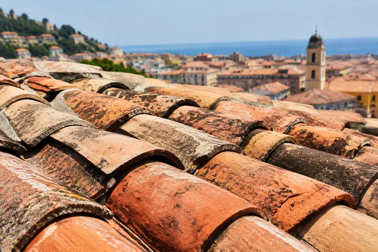 Toiture en tuiles canal sous un fort rayonnement solaire estival à Nice