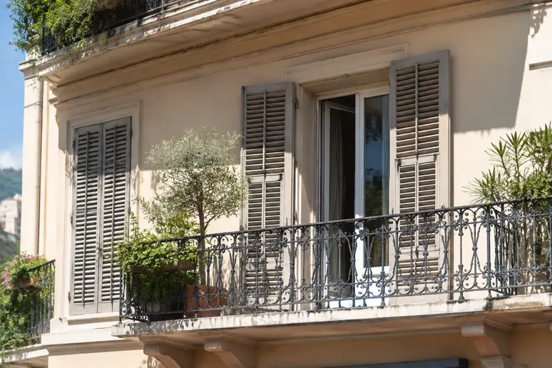 Volets extérieurs entrouverts protégeant du soleil sur un balcon niçois