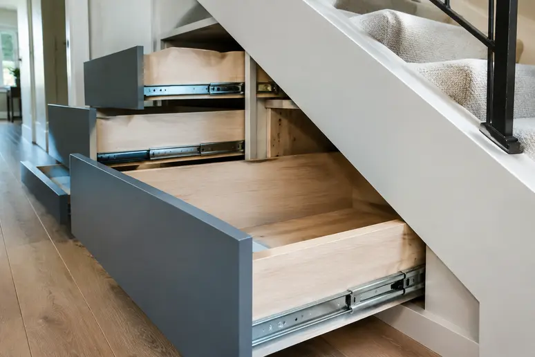 Tiroirs profonds sur mesure installés sous la pente d'un escalier en bois