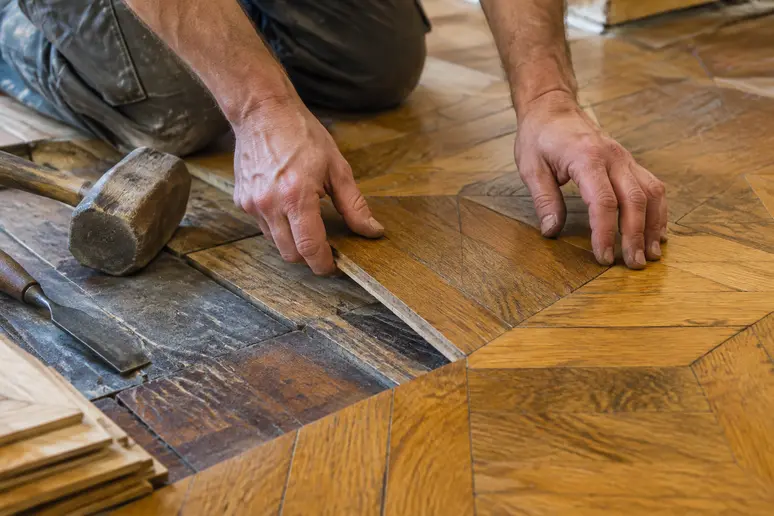 Remplacement précis de lames sur un parquet ancien d'appartement à Nice lors d'une restauration
