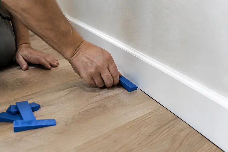 Verification du jeu de dilatation de dix millimetres le long du mur pour eviter le gondolage du parquet