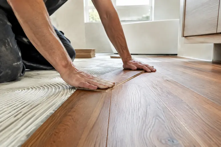 Pose collée d'une lame de parquet salle de bain en bois massif imputrescible