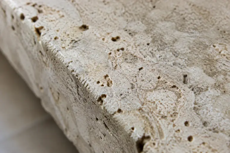 Gros plan sur la texture poreuse et les cavités naturelles d'un sol en pierre naturelle interieur cannes.
