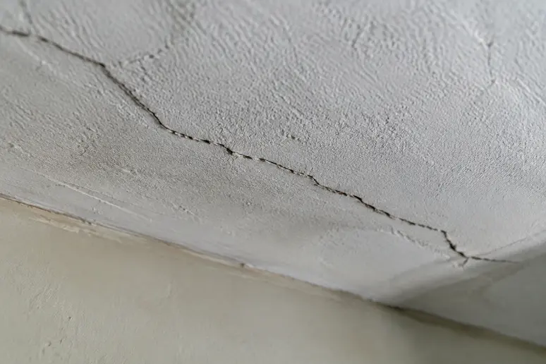 Fissure sur un plafond ancien nécessitant un signalement au syndic de copropriété.