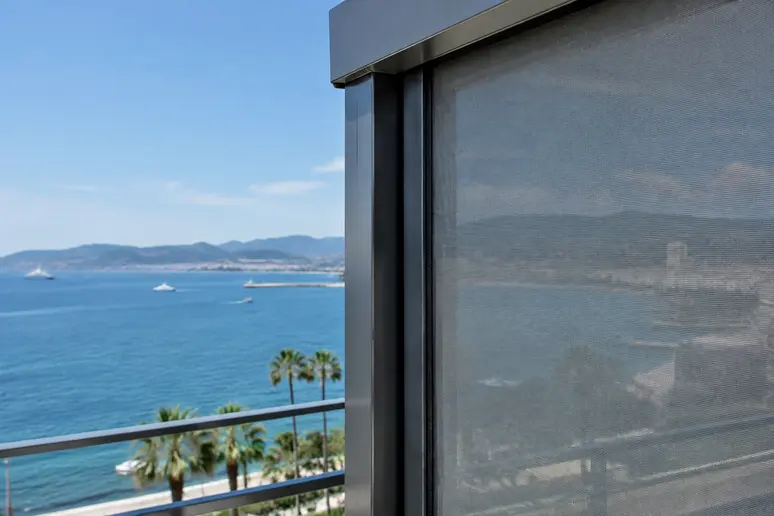 Installation d'un store screen ZIP résistant au vent marin sur un balcon d'appartement à Cannes