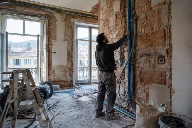 Chantier de rénovation complète dans un appartement niçois avec cloisons ouvertes et réseaux apparents.