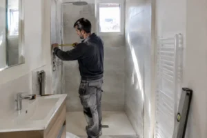 Rénovation d'une salle de bain petite surface Nice par un artisan mesurant le carrelage