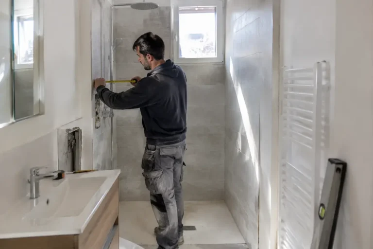 Rénovation d'une salle de bain petite surface Nice par un artisan mesurant le carrelage