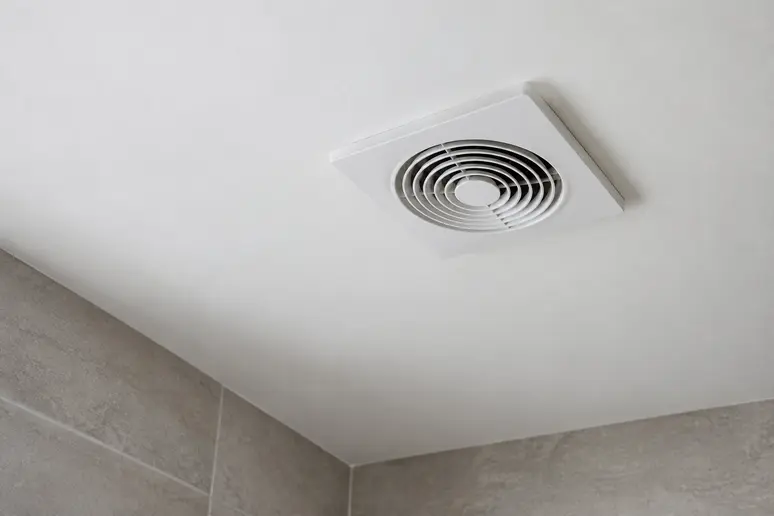 Bouche d'extraction d'une VMC simple flux au plafond d'une salle de bain sans fenêtre