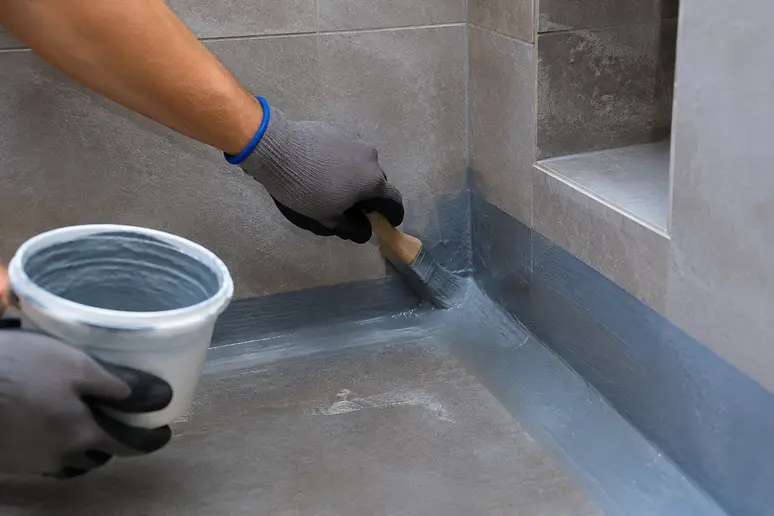 Application de l'étanchéité dans les angles d'une niche salle de bain